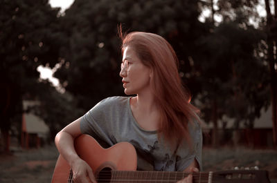 Woman playing guitar in the park