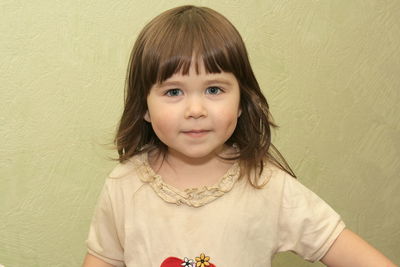 Portrait of cute girl against wall