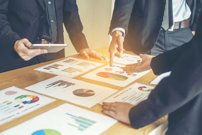 Close-up of businessman and colleague working over graph on table