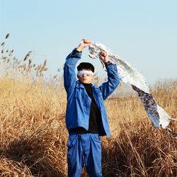 Full length of man standing on field against sky