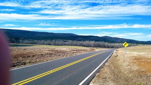 Empty road along countryside landscape