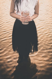 Low section of woman standing on beach