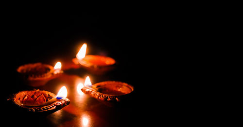 Close-up of lit candles in the dark