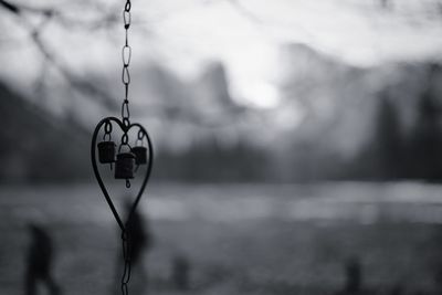 Close-up of heart shape hanging on lake