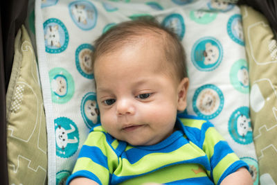 Portrait of cute baby lying on bed