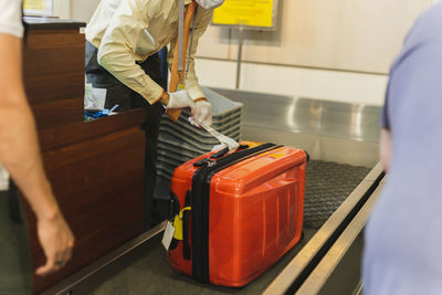 Midsection of woman holding suitcase