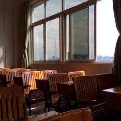 Empty chairs and table by window