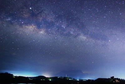 Low angle view of silhouette trees against sky at night