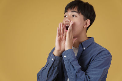 Portrait of boy looking away against wall