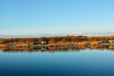 Scenic view of lake against clear blue sky