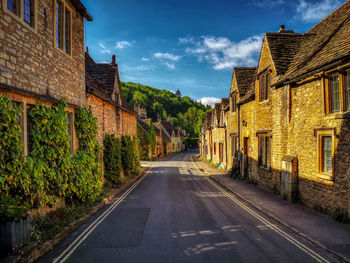 Road amidst buildings against sky