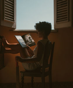 Woman holding a book and a machete 