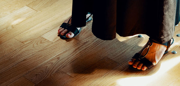 Low section of man standing on hardwood floor