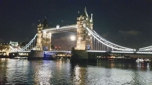 Suspension bridge over river at night