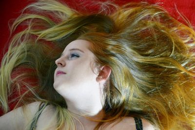 Directly above shot of young woman with long hair lying on bed