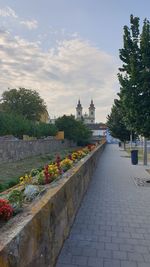 View of footpath amidst buildings against sky