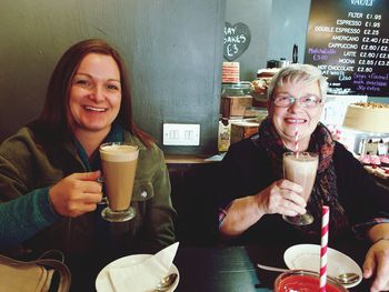 Portrait of smiling women enjoying drinks in cafe