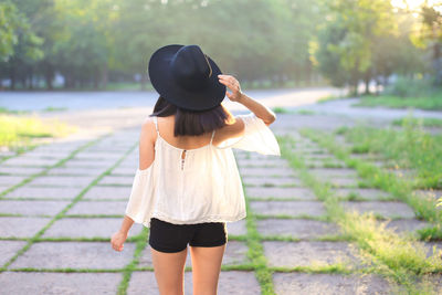 Rear view of woman standing on footpath