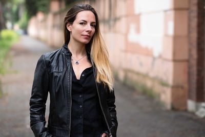 Portrait of beautiful woman standing on footpath