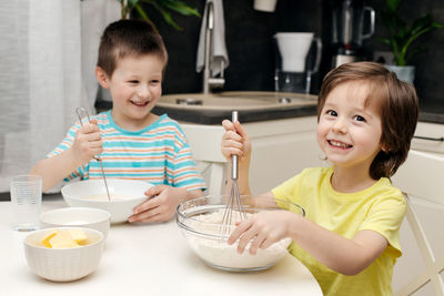 Two brothers prepare cake dough in the kitchen at home. time with children at home. 