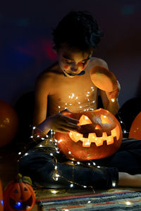 Midsection of man holding pumpkin at home