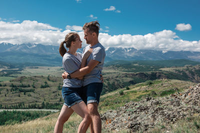 Rear view of friends walking on mountain against sky