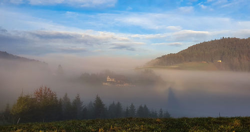 Scenic view of landscape against sky during foggy weather