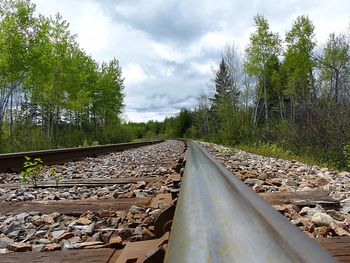 Railroad track against cloudy sky