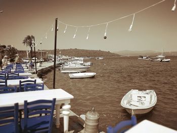 Sailboats moored in harbor against clear sky