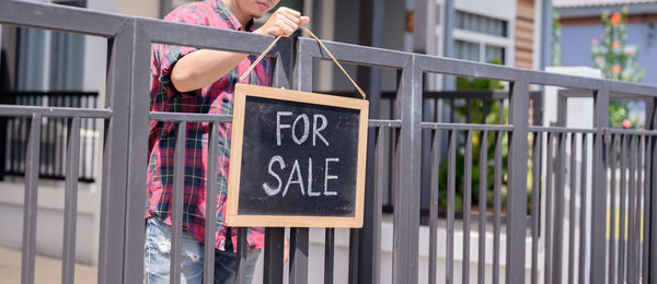 Midsection of woman holding text on wall