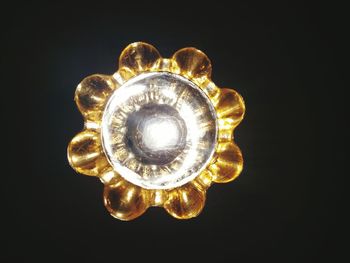 Low angle view of illuminated lamp against black background