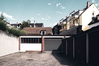 Houses by street against sky