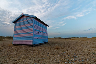 Beach hut on beach against sky