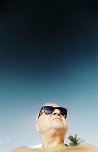 Close-up portrait of man wearing sunglasses against sky