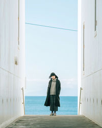 Woman standing by sea against clear sky