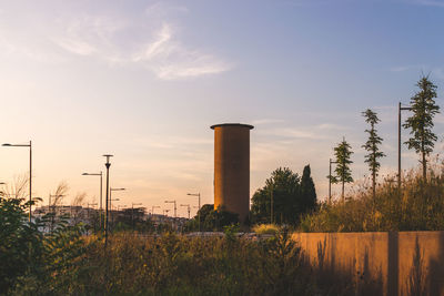 Scenic view of factory against sky during sunset