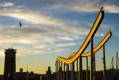 Rambla del mar bridge at port vell against sky during sunset