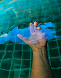Cropped hand of man in swimming in pool