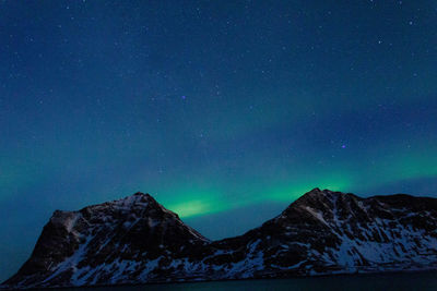 Scenic view of snowcapped mountains against sky at night