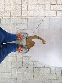 Low section of person standing on tiled floor