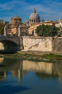 Arch bridge over river against buildings