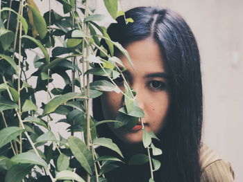 Close-up of young woman with plants