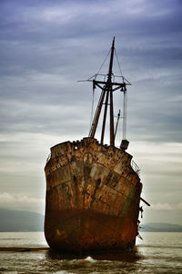 Abandoned boat on sea against sky