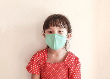 Portrait of a beautiful young woman against white wall