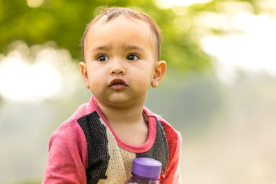 Close-up of cute baby girl looking away