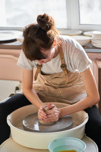 Young woman sitting in kitchen