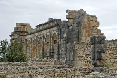 Low angle view of old ruin building against cloudy sky