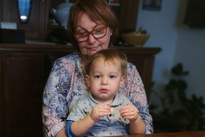 Senior woman sitting with grandson at home