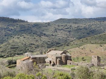 Scenic view of historic building by mountains against sky