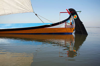 Sailboat moored on sea against sky